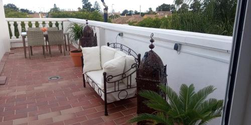 圣费尔南多Room in Lovely cottage house Habitaciones en Chalet en Cadiz San Fernando的露台阳台配有椅子