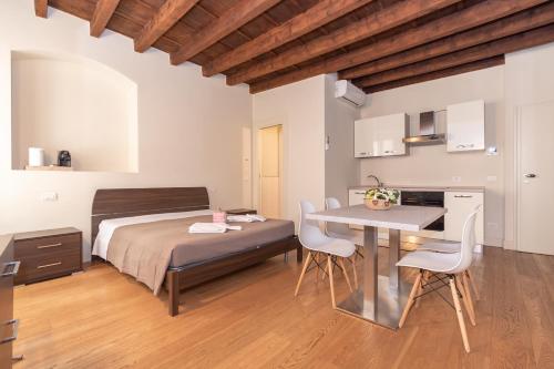 布雷西亚PALAZZETTO IL MANGANO - F&L Apartment的卧室配有一张床和一张桌子及椅子