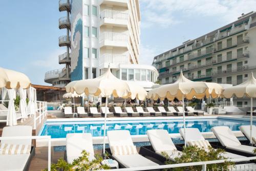 利多迪耶索罗德尔纳西奥尼酒店的酒店旁的游泳池配有椅子和遮阳伞