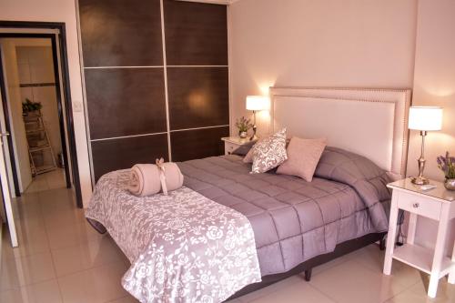 科尔多瓦Departamento de los Boulevares的一间卧室配有一张床、两张桌子和两盏灯。