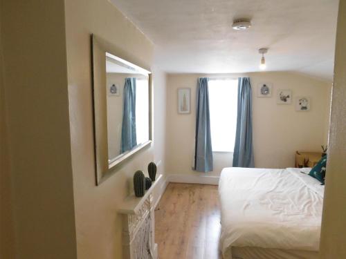 伦敦Entire 4 bedroom Terrace house in London的卧室配有白色的床和镜子