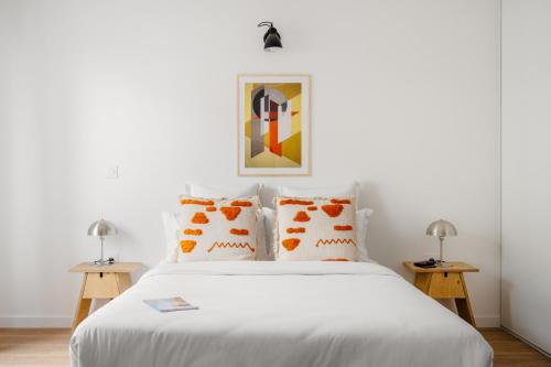 默东Edgar Suites - Meudon-la-Forêt的卧室配有带橙色枕头的白色床