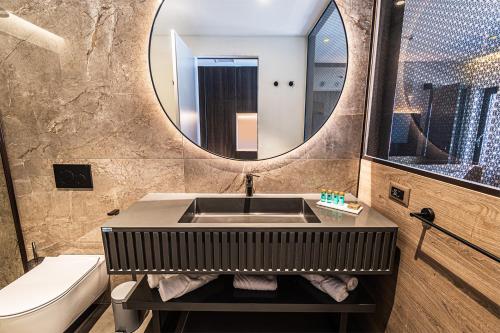 玛里纳Marinus Beach Hotel的一间带水槽、卫生间和镜子的浴室