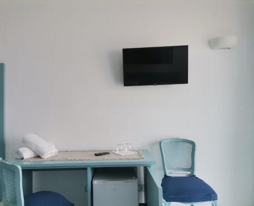 伊斯基亚Residenz e Ristorante da Mimì的一张桌子、两把椅子和墙上的电视
