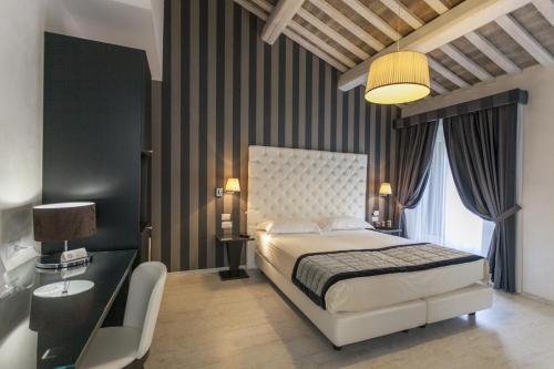 费拉拉那锡那里酒店的一间卧室配有一张床、一张桌子和一盏灯