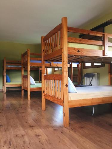 莫利纳塞卡Albergue de peregrinos Santa Marina的铺有木地板的客房内配有三张双层床。