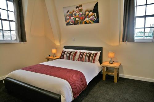 格洛斯特格洛斯特中央酒店的一间卧室配有一张带2个床头柜的大床