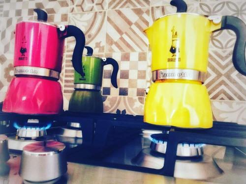 马尔萨拉利伯塔玛萨拉住宿加早餐旅馆的四个不同的彩色咖啡壶,坐在架子上
