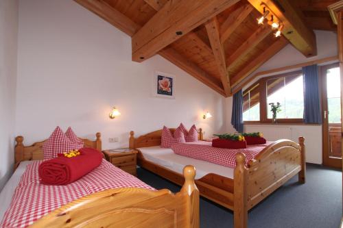 尼德泰Haus Sonneck的一间卧室配有两张带红色枕头的床
