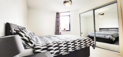伯明翰City Centre 1 Bed Apartment的卧室配有黑白床和镜子