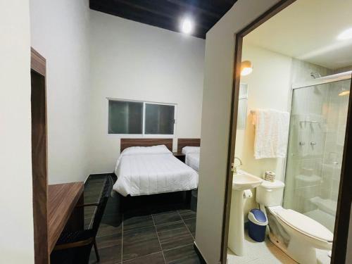 杜兰戈La Casona Real的配有床、淋浴和盥洗盆的浴室