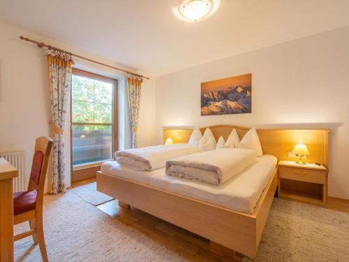 齐勒谷地施特拉斯Schleicherhof V的一间卧室设有两张床和大窗户
