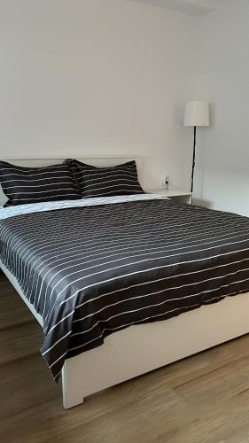 锡纳亚Accommode的一张带黑白棉被和灯的床