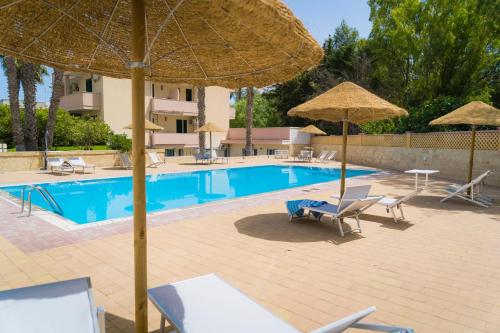 托里德欧索Vaia Residence的一个带遮阳伞和躺椅的游泳池以及一个游泳池