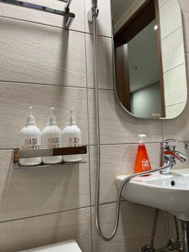 首尔Hao Guesthouse in Hongdae的一间带水槽、卫生间和镜子的浴室