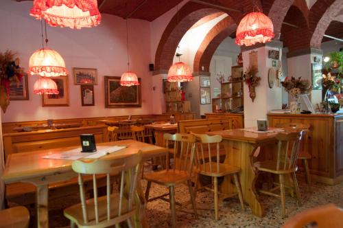 RontaTre Fiumi的餐厅设有木桌、椅子和吊灯。