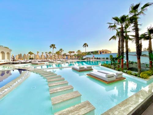 迪迪姆LAUR HOTELS Experience & Elegance的棕榈树度假村游泳池的图片