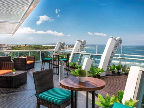 库塔库塔海滩遗产酒店 - 由雅高酒店集团管理的一个带桌椅的海景阳台