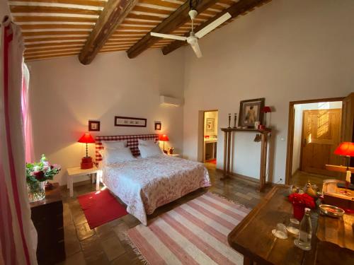 阿维尼翁La ferme de gigognan的一间卧室配有一张床和一张带台灯的桌子