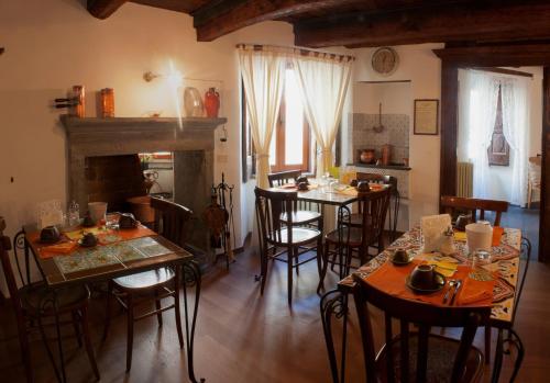 阿尼奥内Il Tomolo的一间带桌椅和壁炉的用餐室