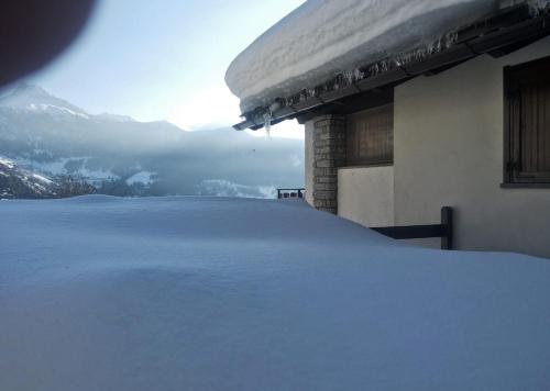 托尔诺Gli appartamenti della Fra的一座山地建筑的雪盖屋顶