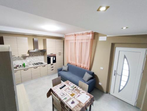 格拉达拉Villa Paoletti, appartamento confortevole nel cuore di Gradara的客厅配有蓝色的沙发和桌子