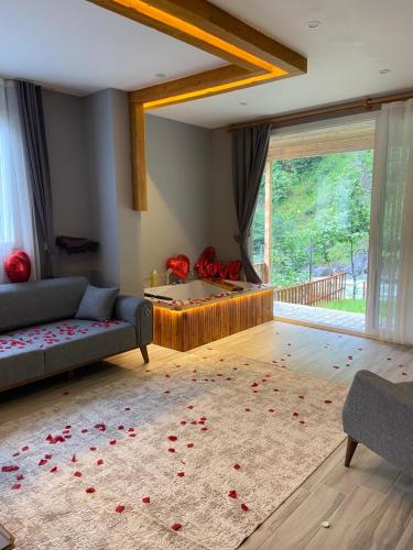 里泽Karadeniz Suit的客厅配有沙发,地板上装饰着红色玫瑰