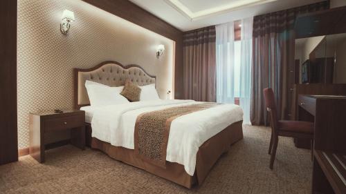 吉赞Al-Borg Hotel的酒店客房设有一张大床和一张书桌。