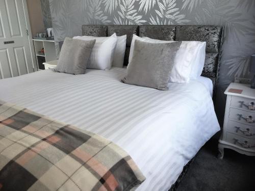 海尔Loggans Lodge的一间卧室配有带白色床单和枕头的床。