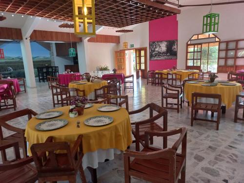 里奥韦尔德Hotel El Molino的餐厅设有黄色的桌椅和粉红色的墙壁