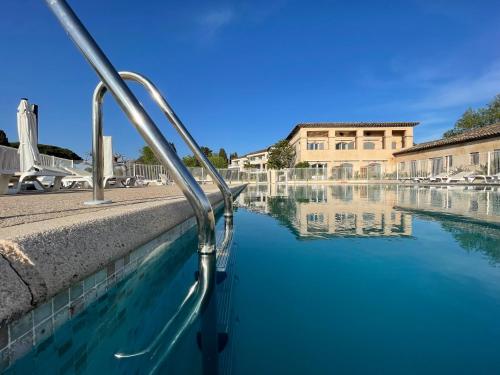 曼德琉-拉纳普勒Studio 15 - LES SUITES DE ROBINSON - Résidence avec piscine en bord de Siagne, à Mandelieu-La-Napoule的水池,建筑背景