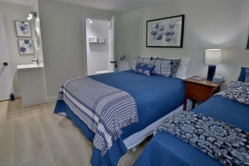 科蒂库克Gîte La Nuitée的一间卧室配有两张带蓝白色床单的床