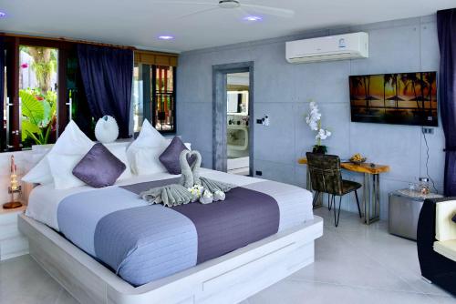 苏梅岛Paradise Villa Elysium的一间卧室配有一张带紫色枕头的大床