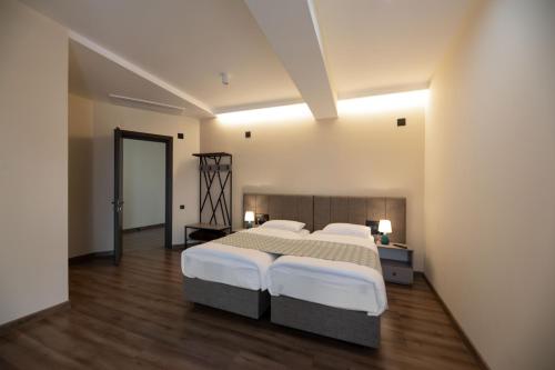 Dedoplis TskaroTakara Hotel & Winery的一间铺有木地板并配有两张床的大卧室
