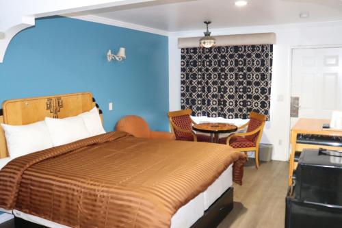 加迪纳市埃多拉多汽车旅馆的卧室配有一张床和一张桌子及椅子