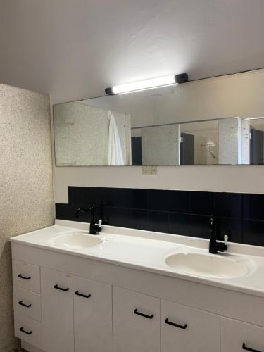 古尔本Tattersalls Hotel的一间带两个盥洗盆和大镜子的浴室