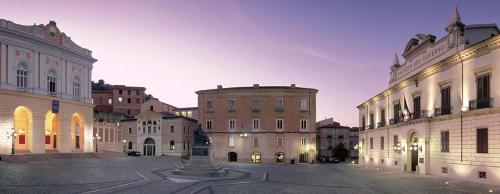科森扎Palazzo Lupinacci - dimora storica Bed and breakfast的夜空城市的一群建筑