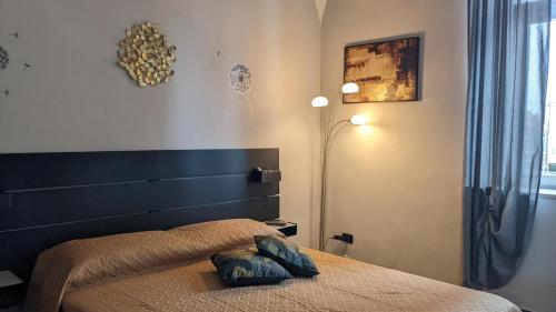 奥托纳IL Castelletto的一间卧室配有一张带床头板和灯的床