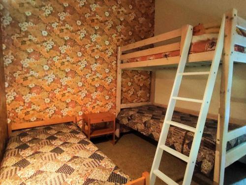 科特雷Appartement Cauterets, 3 pièces, 6 personnes - FR-1-234-252的一间卧室设有两张双层床,墙上挂着鲜花。
