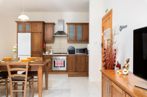 姆西达Spacious, Bright & Cosy 2 Bedroom 2 Bathroom Apartment - Msida Uni Heights的厨房配有木制橱柜和桌椅