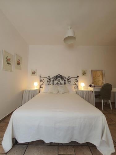莱切A casa di Carla - Villa in Salento的一间卧室配有一张带两盏灯的大型白色床。