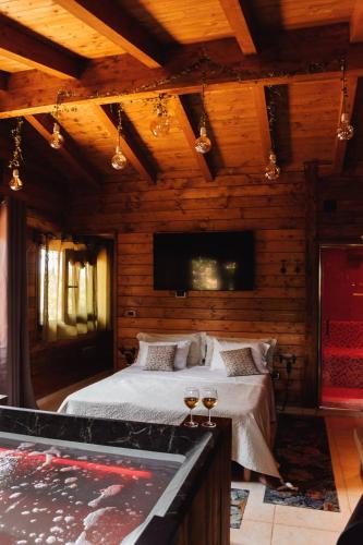 奇斯泰尼诺Mini spa in chalet bosco的一间卧室配有一张带两杯葡萄酒的床