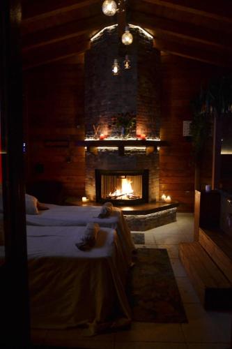 奇斯泰尼诺Mini spa in chalet bosco的一间设有壁炉的房间,前面设有一张床