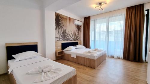 艾福雷诺德Vila Natalia的酒店客房设有两张床和大窗户。