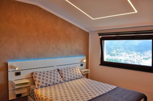 诺利Spettacolare vista isola Terrazza e idromassaggio的一间卧室设有一张床和一个窗口