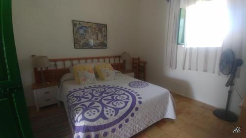 圣费兰-德瑟斯罗Can Xumeu Miquel的一间卧室配有一张带白色和紫色毯子的床