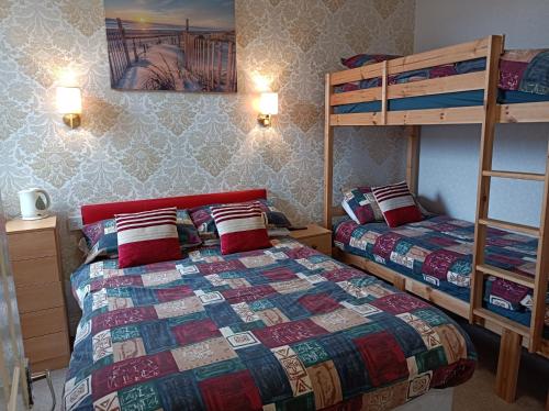 布莱克浦Stafford House的一间卧室配有两张床和一张双层床。