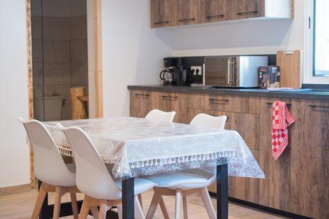 拉萨尔韦塔Ranch du Haut-Languedoc的厨房配有带白色椅子的桌子和台面