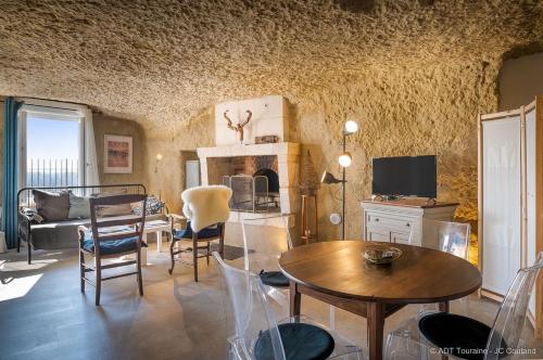 武夫赖La cavée du coteau, petit cocon troglodytique的客厅配有桌椅和电视。