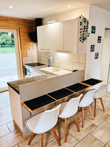 Prat-et-BonrepauxChalet des illes BERMUDE III的厨房配有白色橱柜和桌椅